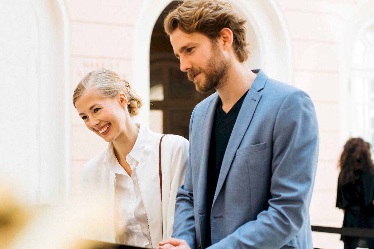 A couple stands at the ticket office in the Albertina Court, the blonde woman smiles. | Photo © Marko Mestrovic