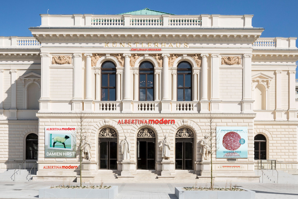 Frontalansicht des klassizistischen Gebäudes der ALBERTINA MODERN mit Statuen, Säulen und Ausstellungspostern | Foto (Mockup) © Rupert Steiner