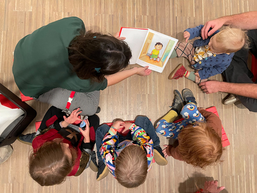 Kunstvermittlerin liest mit einer Gruppe Kinder aus einem Bilderbuch. | Foto © ALBERTINA, Wien