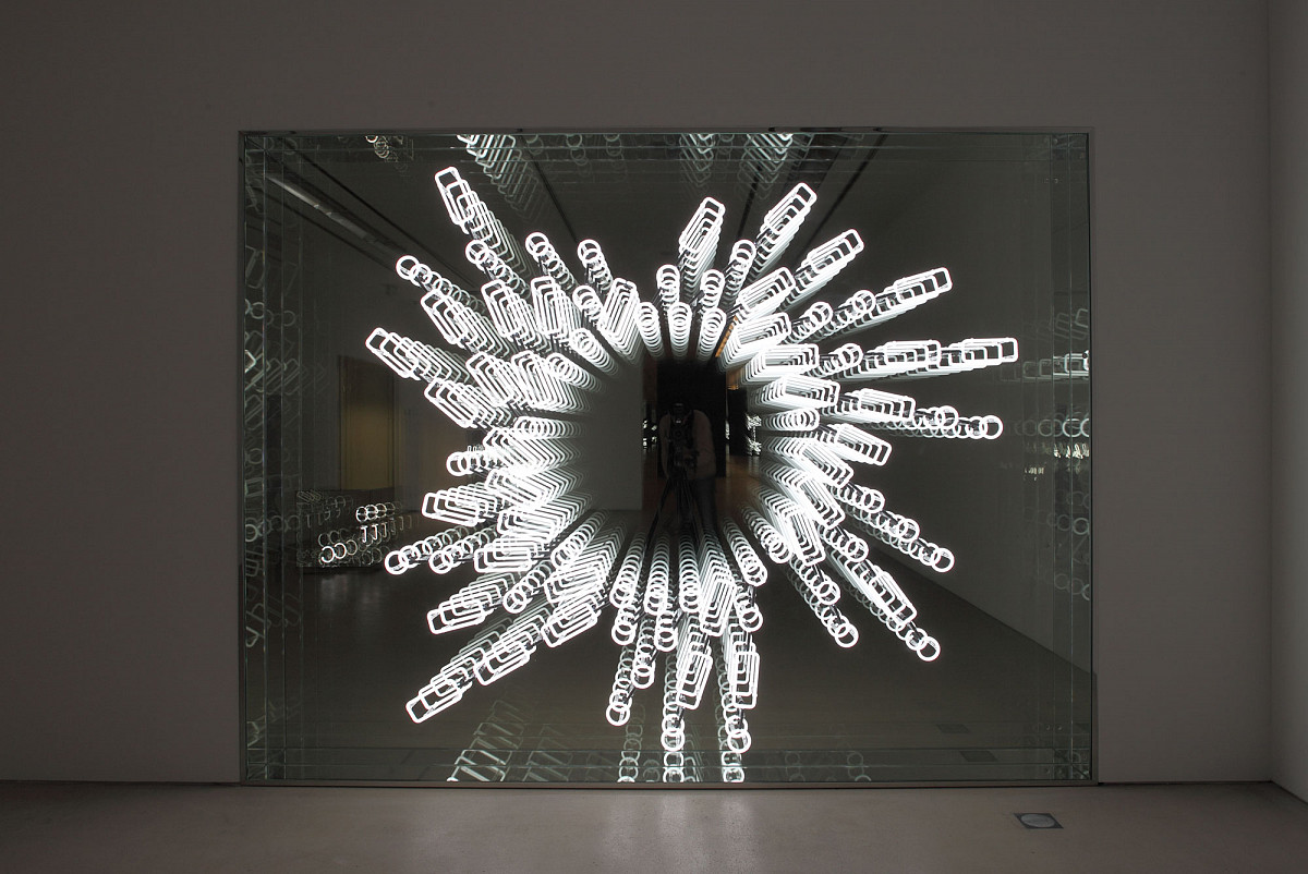 There are glowing circles and rectangles on a mirror, which spiral outwards from a circle in the center.