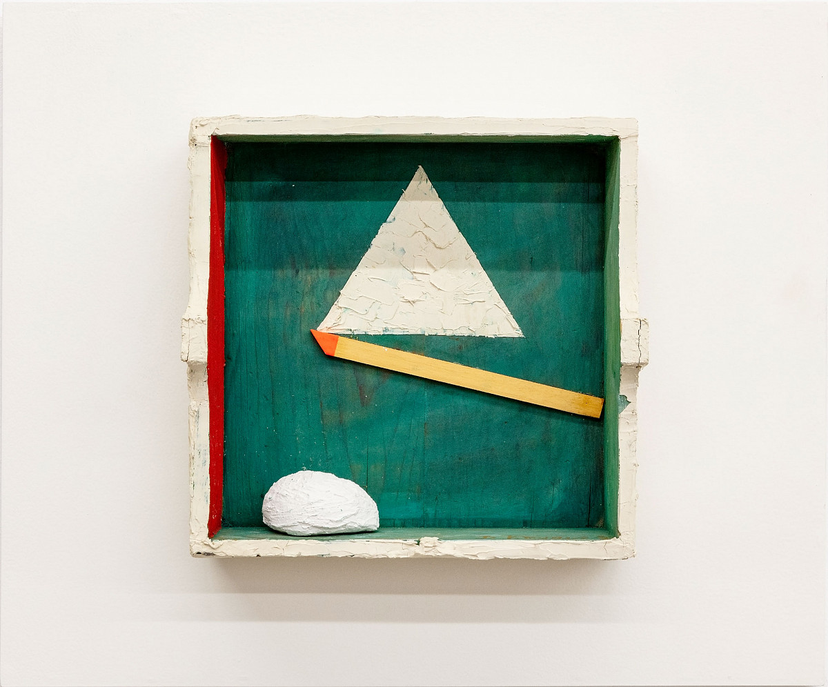 An open, square box painted green on the inside, apart from a white triangle in the middle. Below the triangle is an oblique elongated line in yellow. At the bottom of the box on the left-hand side is what looks like a white absorbent cotton ball.