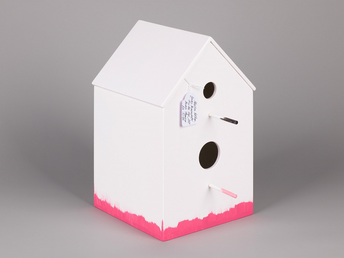 Birdhouse in white with pink trim on the underside.