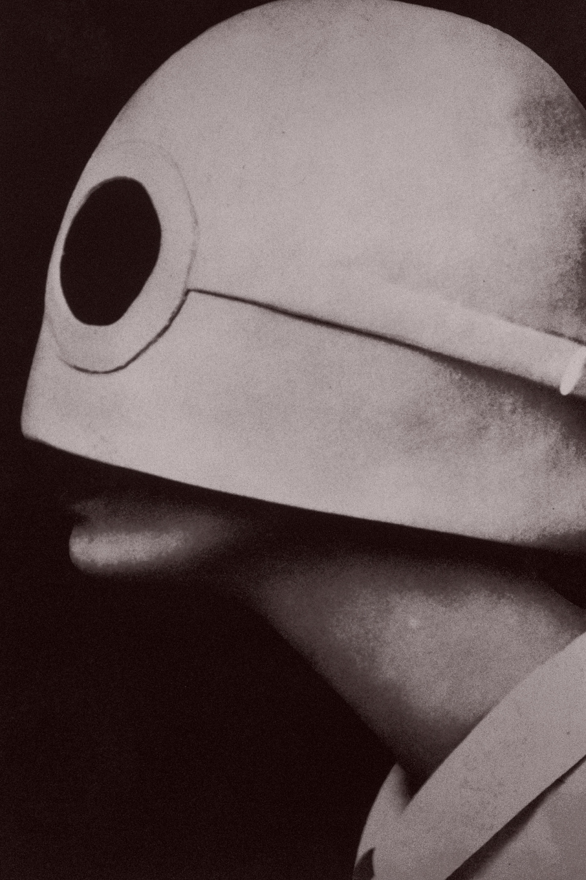 A head in a side profile, wearing a large hat that covers the entire face except for the area just above the mouth.