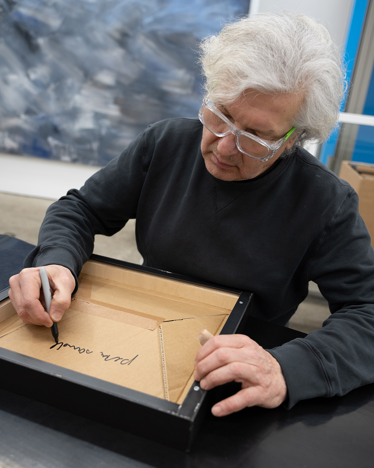 Der Künstler beim Signieren der Werke.