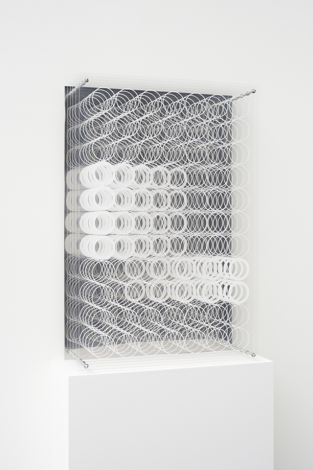 A metal mirror above which several pieces of Plexiglas are mounted. The Plexiglas shows thin rings next to each other.