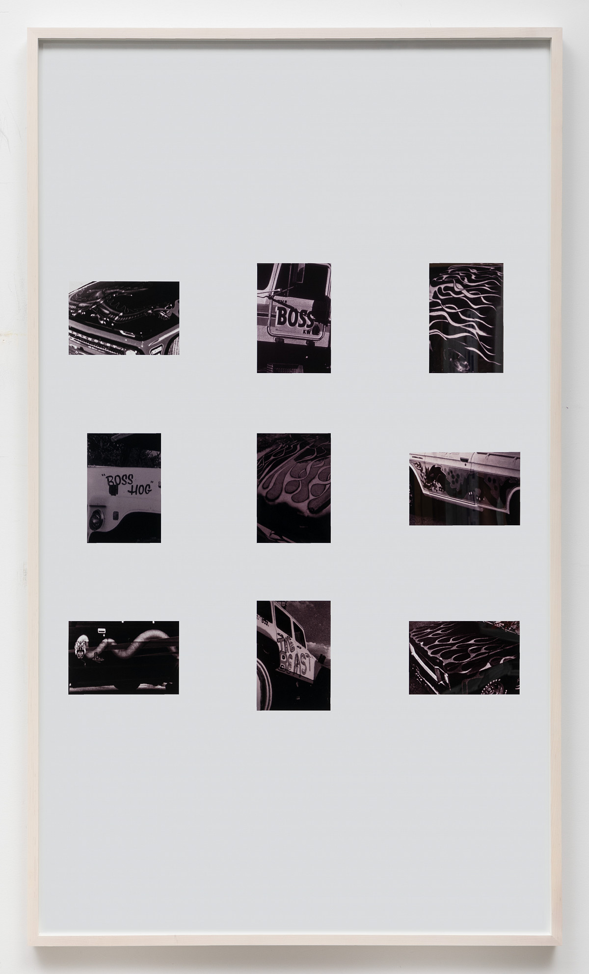 A picture frame containing three rows of three small black-and-white photographs each.