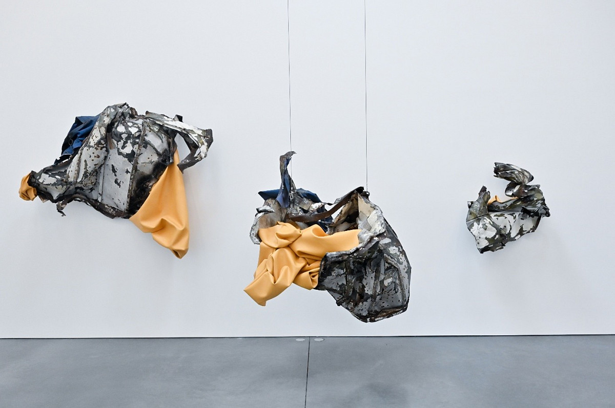 Parts that look like scrap metal hang from the ceiling or are mounted on the wall.