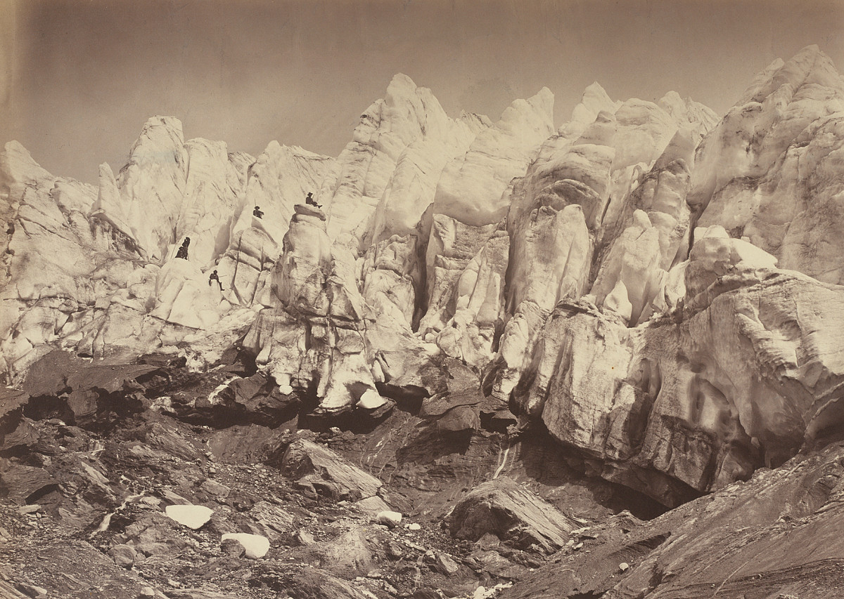 Glacier with snow-covered slopes and a rocky foreground.