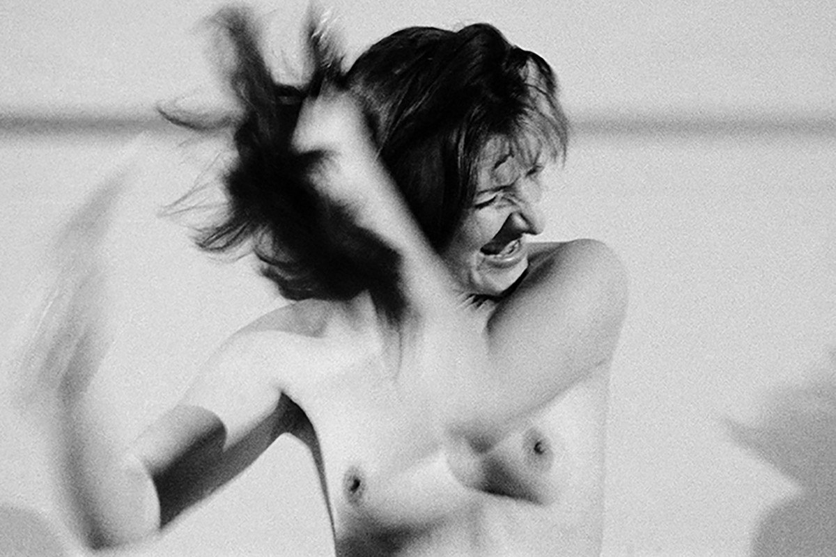 The artist brushes her hair wildly with her upper body naked. Credit: Marina Abramović | Art must be beautiful / Artist must be beautiful, 1975/2025